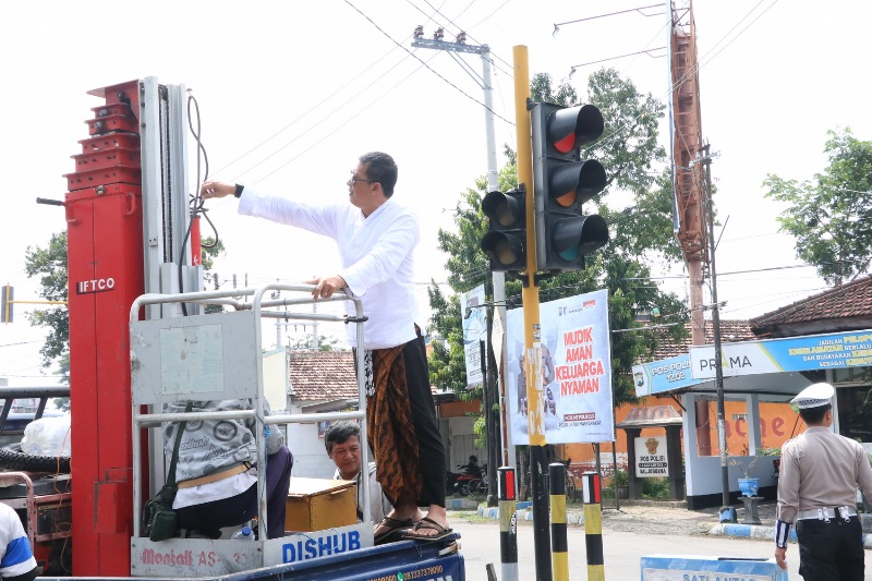Kabid Lalu Lintas dan Sarpras Dishub Ponorogo Setyo Budiono menaiki crane untuk memantau perbaikan traffic light, Selasa (18/3).