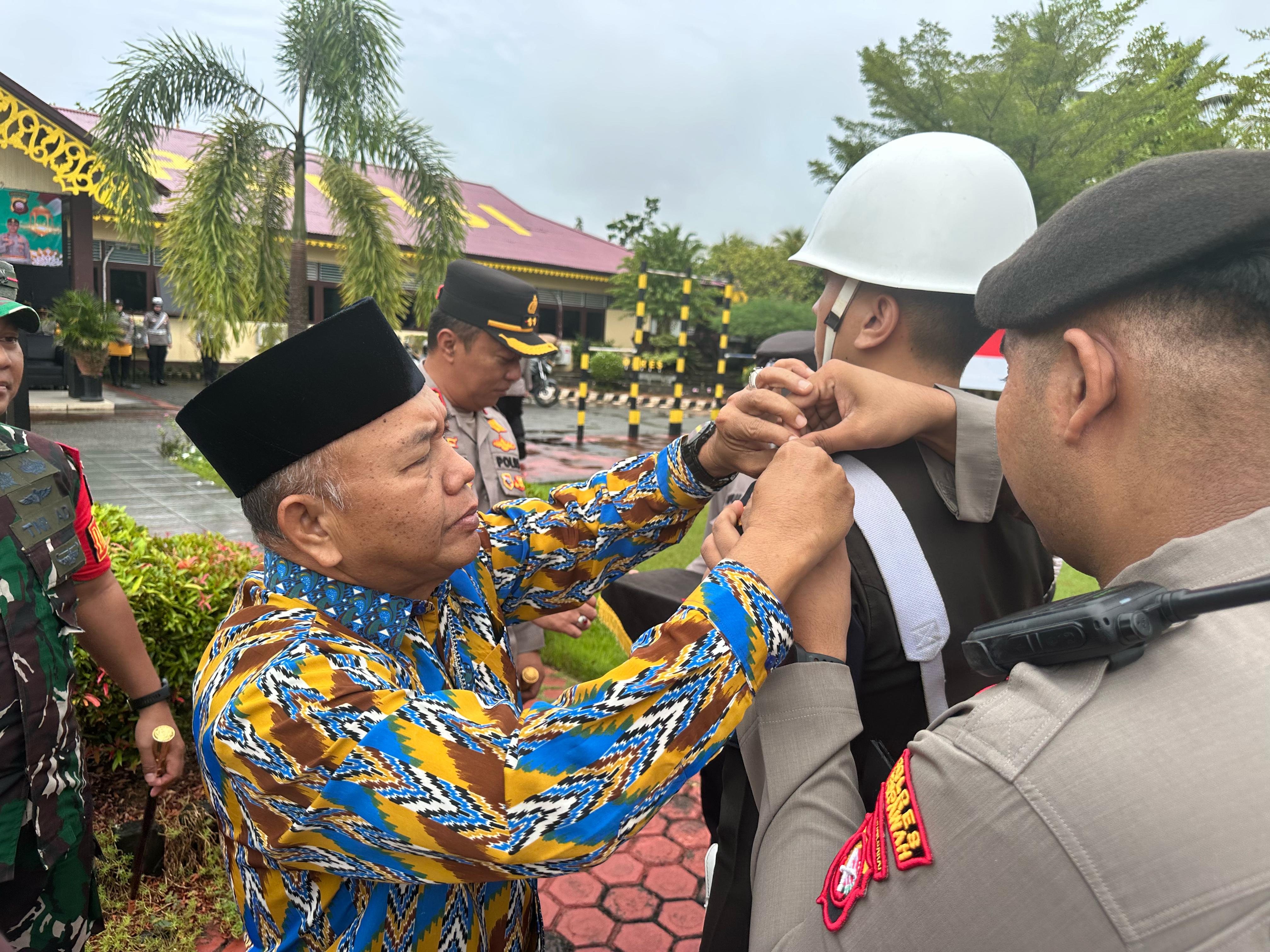 Wabup menyematkan tanda pelaksanaan Operasi Ketupat kepada petugas.