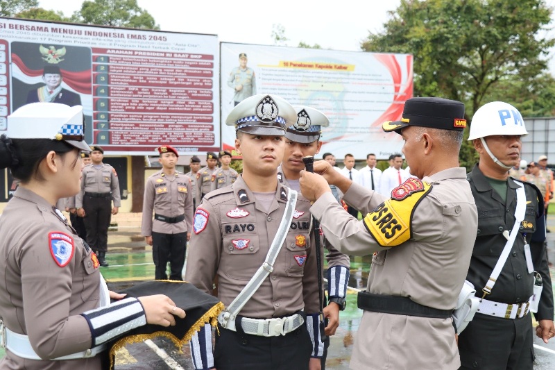 Kapolres Melawi AKBP Muhammad Syafii menyematkan pita kepada personel yang terlibat dalam Operasi Ketupat 2025 di halaman apel Bhayangkara Polres Melawi.