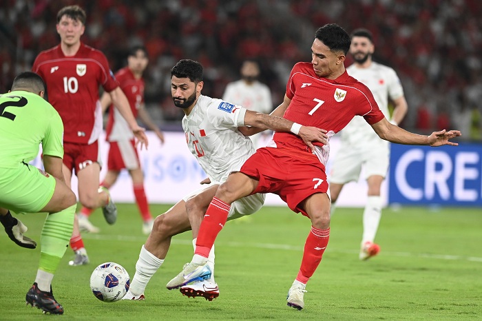 Pesepak bola Timnas Indonesia Marselino Ferdinan (kanan) berebut bola dengna pesepak bola Timnas Bahrain Ahmed Bughammar (tengah) dalam pertandingan Grup C putaran ketiga Kualifikasi Piala Dunia 2026 zona Asia di Stadion Utama Gelora Bung Karno, Senayan,