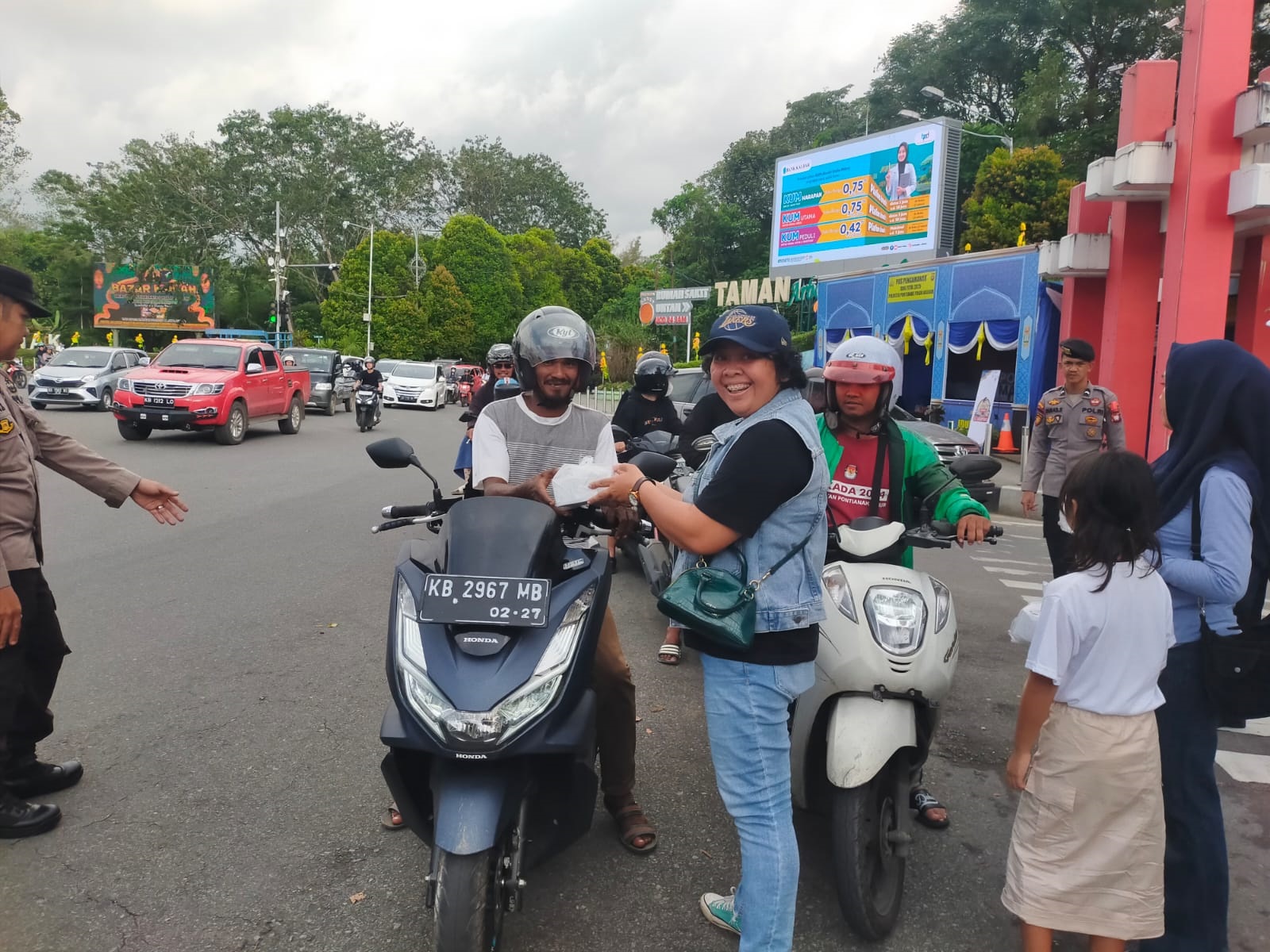 BAGI TAKJIL: Pengurus Kesatu Kalbar sedang membagikan takjik ke pengendara yang melintas di sekitar Bundaran Digulis Untan.