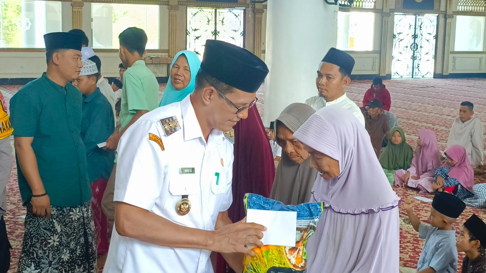 SANTUNAN: Wakil Bupati Kayong Utara, Amru Chanwari, menyerahkan santunan kepada anak yatim dan kaum duafa di Masjid Agung Oesman Al-Khair.