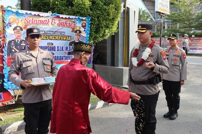 DISAMBUT: AKBP Jonathan David saat tiba di Mapolres Mempawah disambut dengan adat tepung tawar.