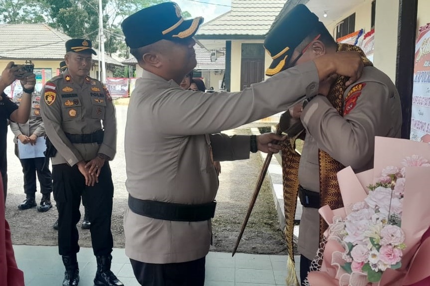 Kapolres Sambas AKBP Wahyu Jati Wibowo didampingi istri saat mengalungkan syal dan bunga kepada AKBP Sugiyatmo dan Istri saat pelepasan, Jumat (11/4).