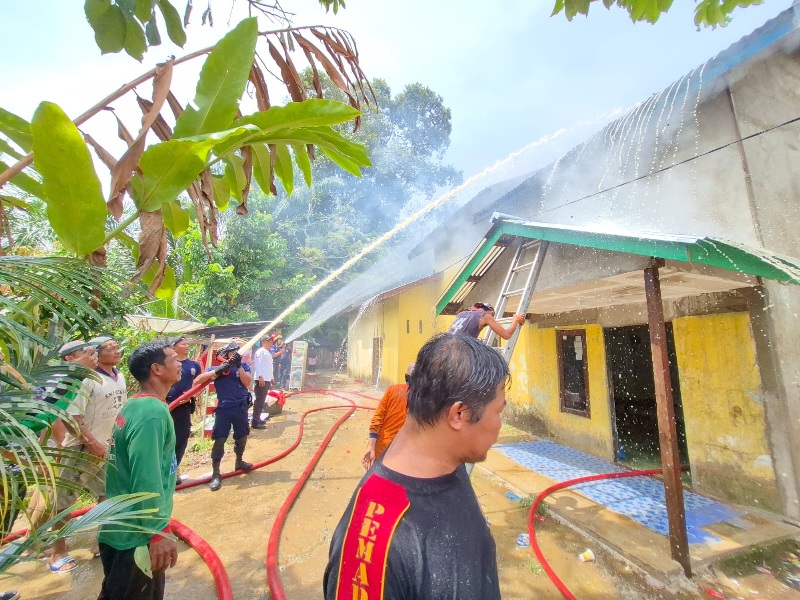 Petugas berupaya memadamkan api yang membakar rumah warga di Sekadau Hilir.