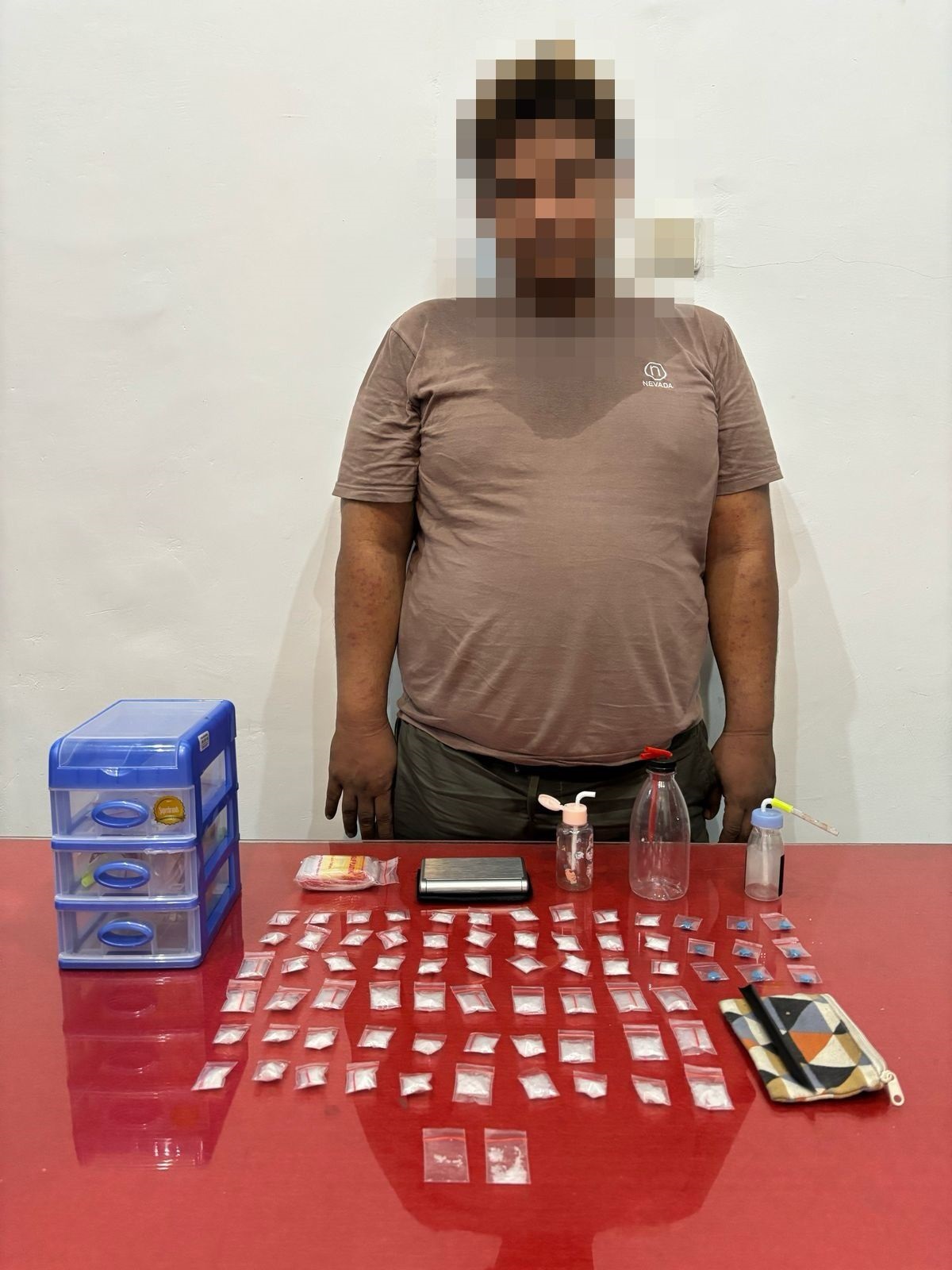 AMANKAN: Salah satu tersangka dengan sejumlah barang bukti narkotika.
