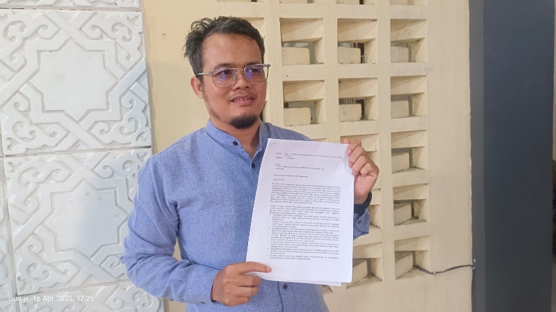 Pelapor Sumin menunjukkan berkas laporan pimpinan Masjid Al-Mu