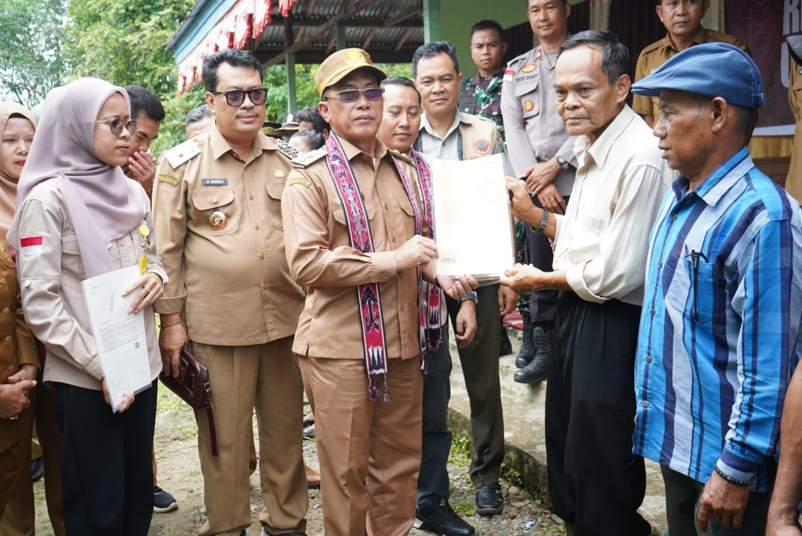 PENYERAHAN: Wakil Bupati Kapuas Hulu Sukardi saat menyerahkan sertifikat redistribusi TORA kepada warga Transmigrasi.