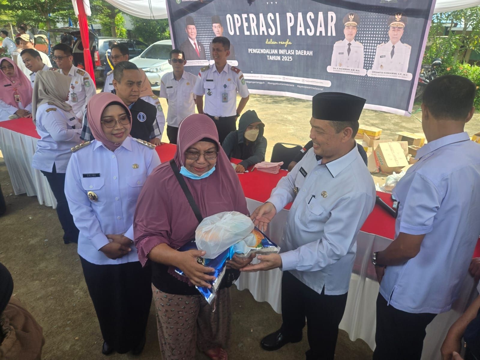 SERAHKAN SEMBAKO: Gubernur Ria Norsan didampingi Bupati Mempawah Erlina secara simbolis menyerahkan paket sembako saat operasi pasar murah di Mempawah.