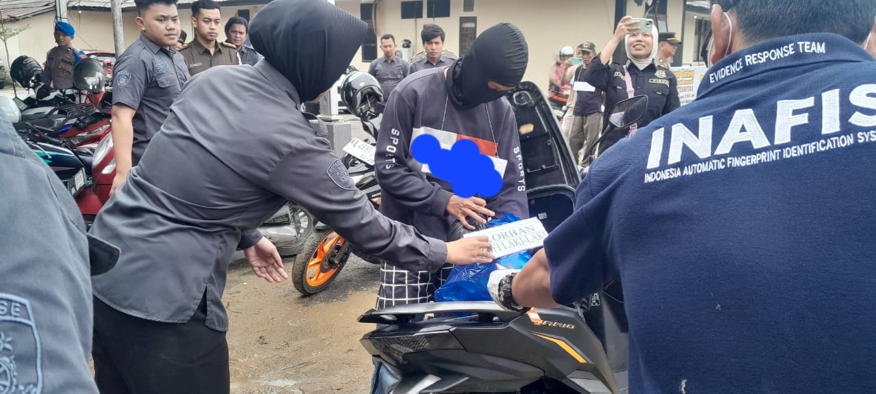 REKONSTRUKSI: ICL perankan adegan saat memasukkan jasad bayinya yang dibungkus plastik ke dalam jok motor untuk dibawa selanjutnya dibuang di sungai, Kamis (24/4).