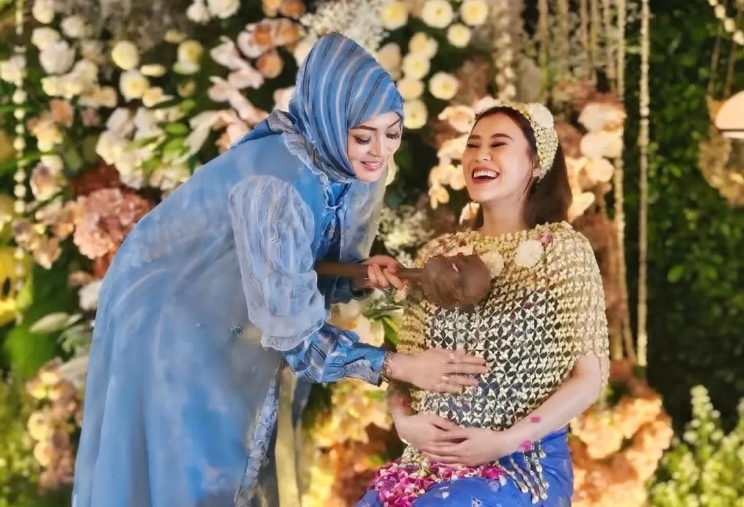 Momen saat Angelina Sondakh menyiram Aaliyah Massaid dengan air suci di acara tujuh bulan kehamilan