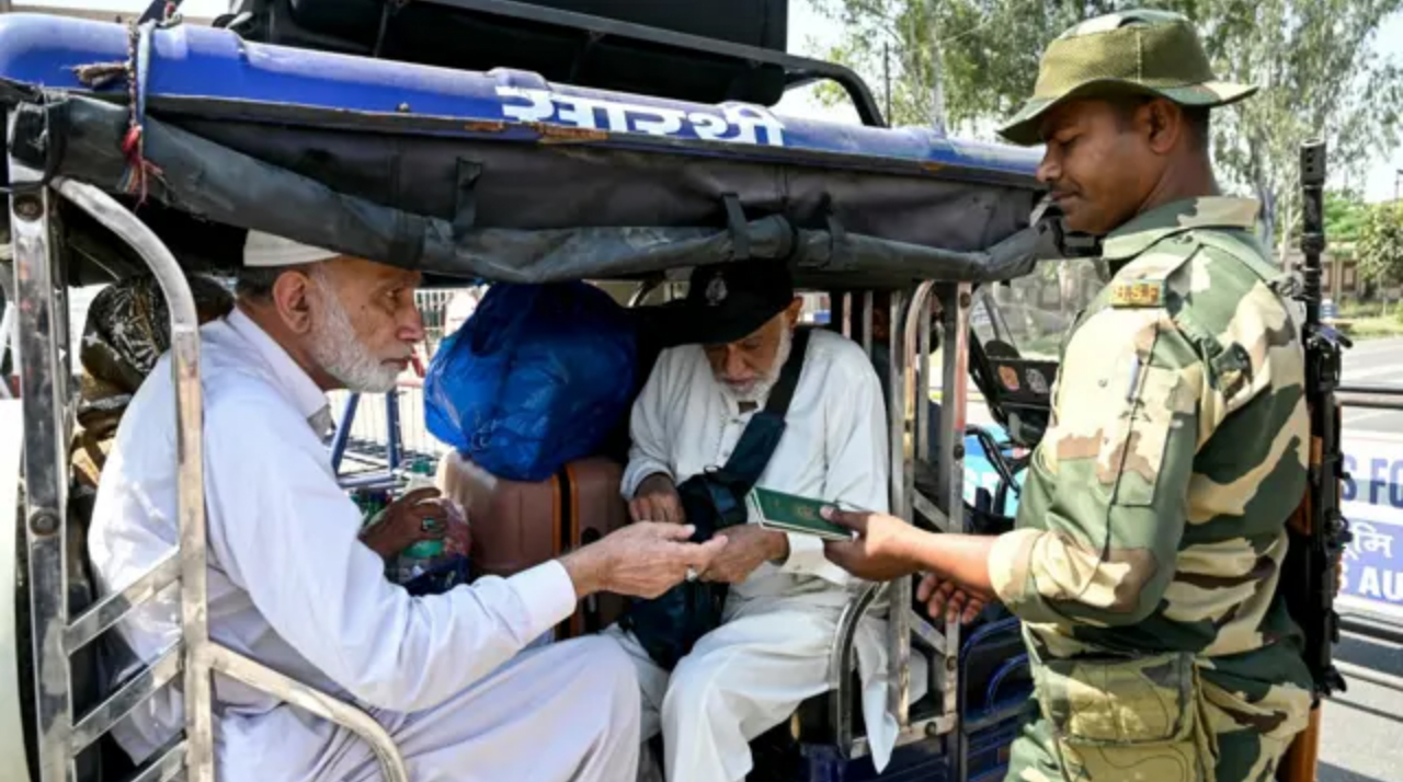 Seorang Tentara India Penjaga Perbatasan (BSF) memberikan jalan bagi warga India yang pulang dari Pakistan di pos perbatasan Wagah, 35 kilometer dari Amritsar, kemarin (27/4).