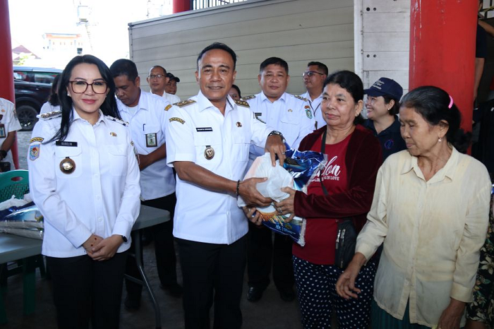 PASAR MURAH: Wakil Gubernur Krisantus Kurniawan menyerahkan bahan pokok yang dibeli warga dalam pasar murah yang digelar Pemprov Kalbar di Kabupaten Landak.