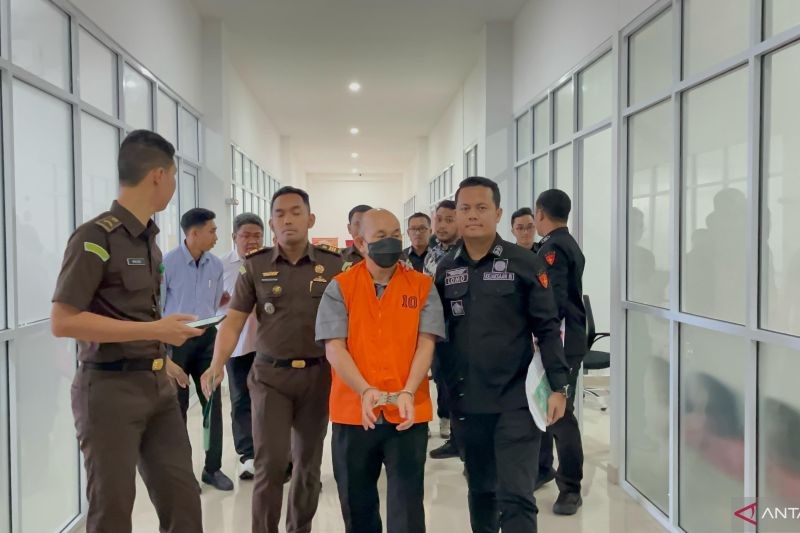 DITAHAN: Petugas Kejari Pontianak menggiring Kepala Dinas Kominfo Kalbar, S setelah diperiksa dan menetapkannya sebagai tersangka.