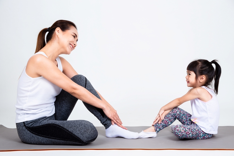 Ilustrasi ibu dan anak melakukan olahraga yoga di rumah.