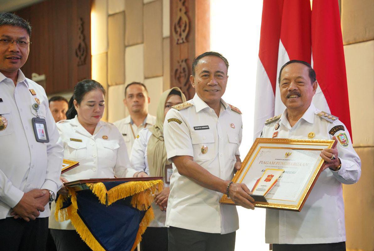 PENGHARGAAN : Bupati Sanggau Yohanes Ontot saat menerima penghargaan yang diserahkan oleh Wagub Kalbar, Krisantus Kurniawan.