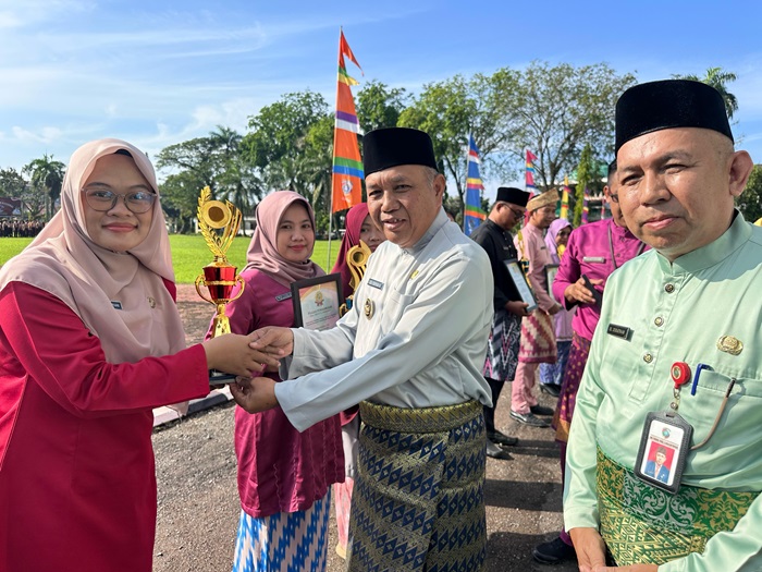 TERIMA PIAGAM: Guru pemenang OGN tingkat Kabupaten Mempawah menerima piagam dan penghargaan yang diserahkan Wabup Juli Suryadi.