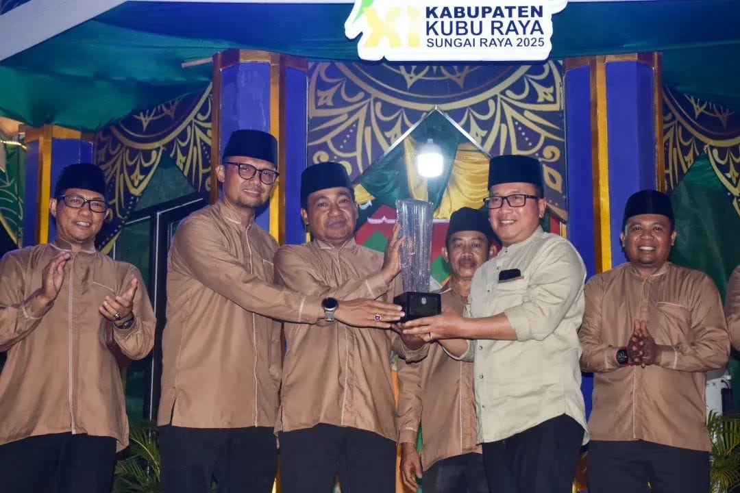 SERAHKAN PIALA: Bupati Kubu Raya, Sujiwo, menyerahkan piala kepada perwakilan Kafilah Sungai Kakap yang kembali meraih gelar juara umum MTQ XI tingkat Kubu Raya, pada Sabtu malam (3/5).