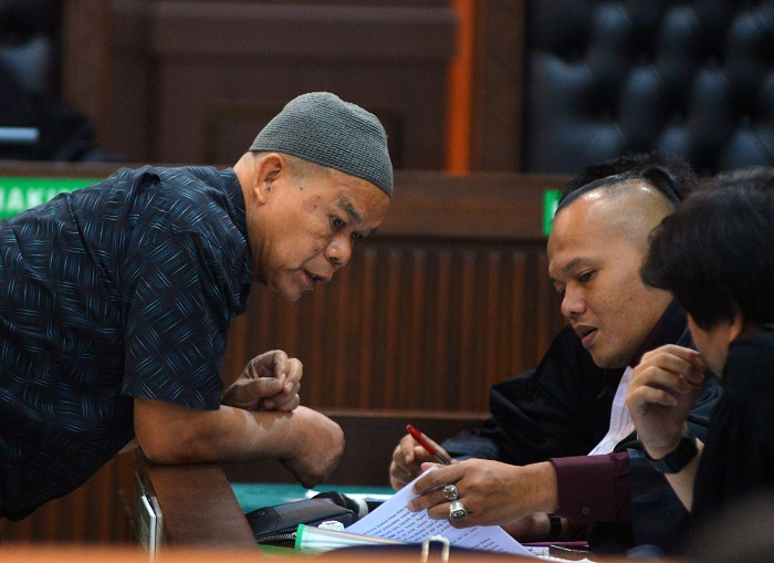 Terdakwa kasus pembunuhan Kasat Reskrim Polres Solok Selatan AKP Ulil Ryanto Anshar,&nbsp;Dadang Iskandar (kiri) berdiskusi dengan penasehat hukumnya saat sidang perdana di Pengadilan Negeri Padang, Sumatera Barat, Rabu (7/5/2025). Sidang perdana dengan t