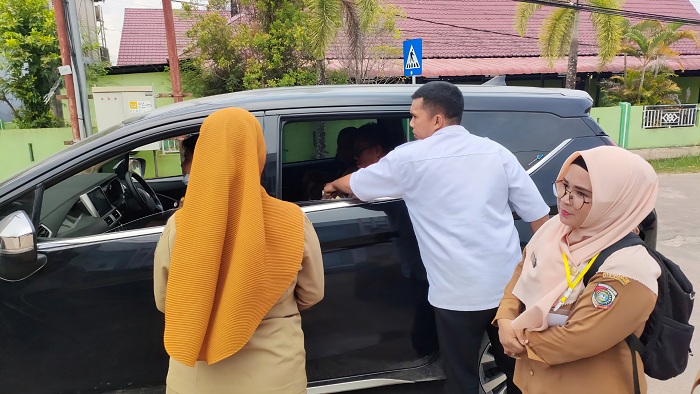 DIAMANKAN : Mila saat diamankan staf Kelurahan dan anggota Polsek Sungai Pinyuh menggunakan kendaraan roda empat di Jalan Pendidikan
