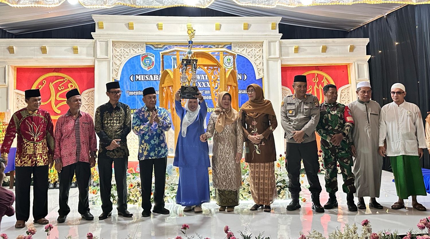 BERGILIR: Kades Penibung mengangkat piala bergilir sebagai juara umum MTQ tingkat Kecamatan Mempawah Hilir.