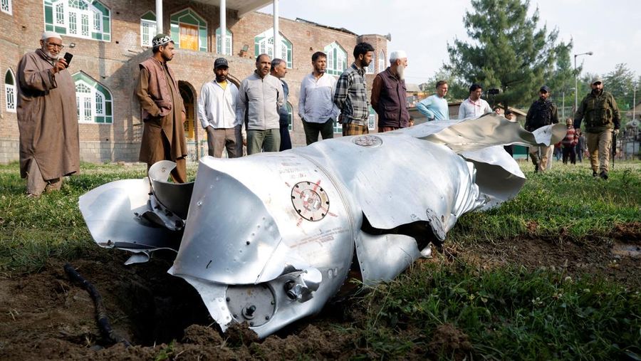 Penduduk desa menunjukkan serpihan pesawat yang jatuh di Desa Wuyan, sekitar 19 kilometer dari Srinagar, Kashmir.