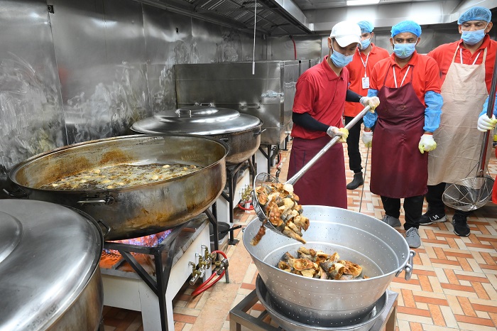 Juru masak mengangkat ikan patin goreng untuk lauk paket makan siang jamaah calon haji Indonesia di dapur Raghaeb Catering, Makkah, Arab Saudi, Rabu (14/5/2025).  Menu makanan jamaah calon haji Indonesia bercita rasa nusantara dengan menggunakan bumbu kha