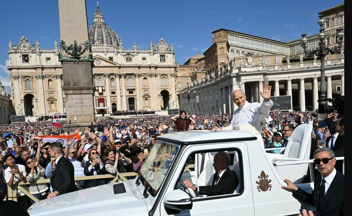 Paus Leo XIV dengan menaiki popemobile menyapa puluhan ribu umat di Lapangan Santo Petrus, Basilika, Vatikan, Minggu (18/5).