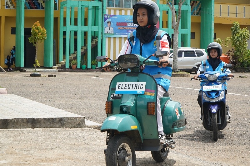 Siswi SMK Negeri 4 Pontianak melakukan uji coba sepeda motor yang telah dikonversi dari berbahan bakar minyak menjadi kendaraan listrik berbasis baterai.