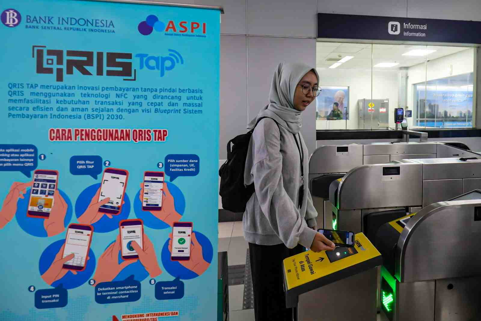 Calon penumpang menempelkan ponsel ke mesin pemindai untuk membayar kereta Moda Raya Terpadu (MRT) di Stasiun MRT Bundaran HI, Jakarta, Jumat (14/3/2025).
