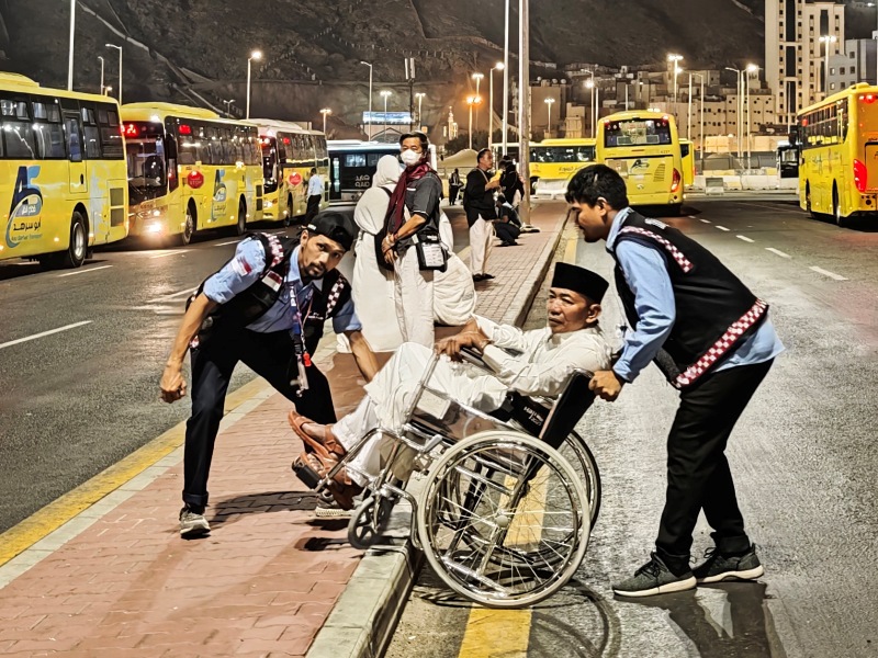 Petugas Penyelenggara Haji Indonesia (PPIH) membantu calon haji disabilitas menuju bus Shalawat di terminal Shib Amir Masjidil Haram, Makkah, Arab Saudi, Rabu (21/5/2025).