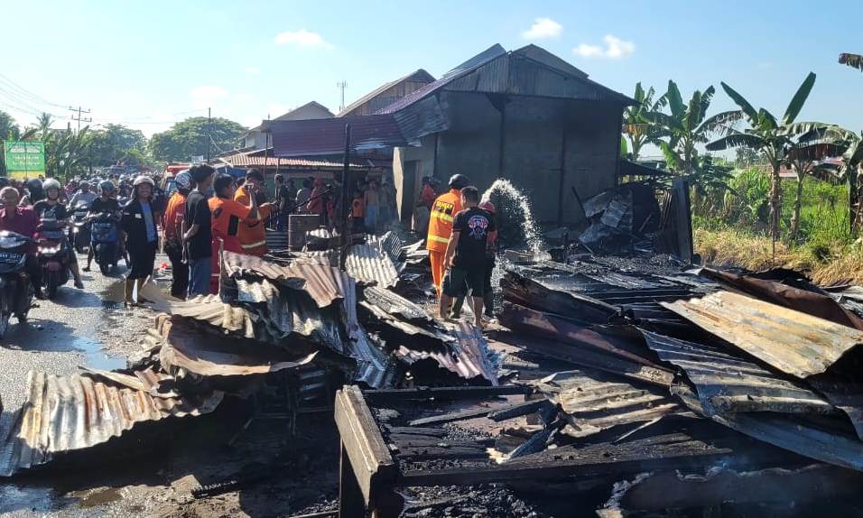 Petugas damkar bersama warga berupaya memadamkan sisa api usai kebakaran yang meludeskan empat kios di Jalan Pramuka, Dusun Cendana, Desa Sungai Rengas, Kecamatan Sungai Kakap, Minggu pagi (25/5).