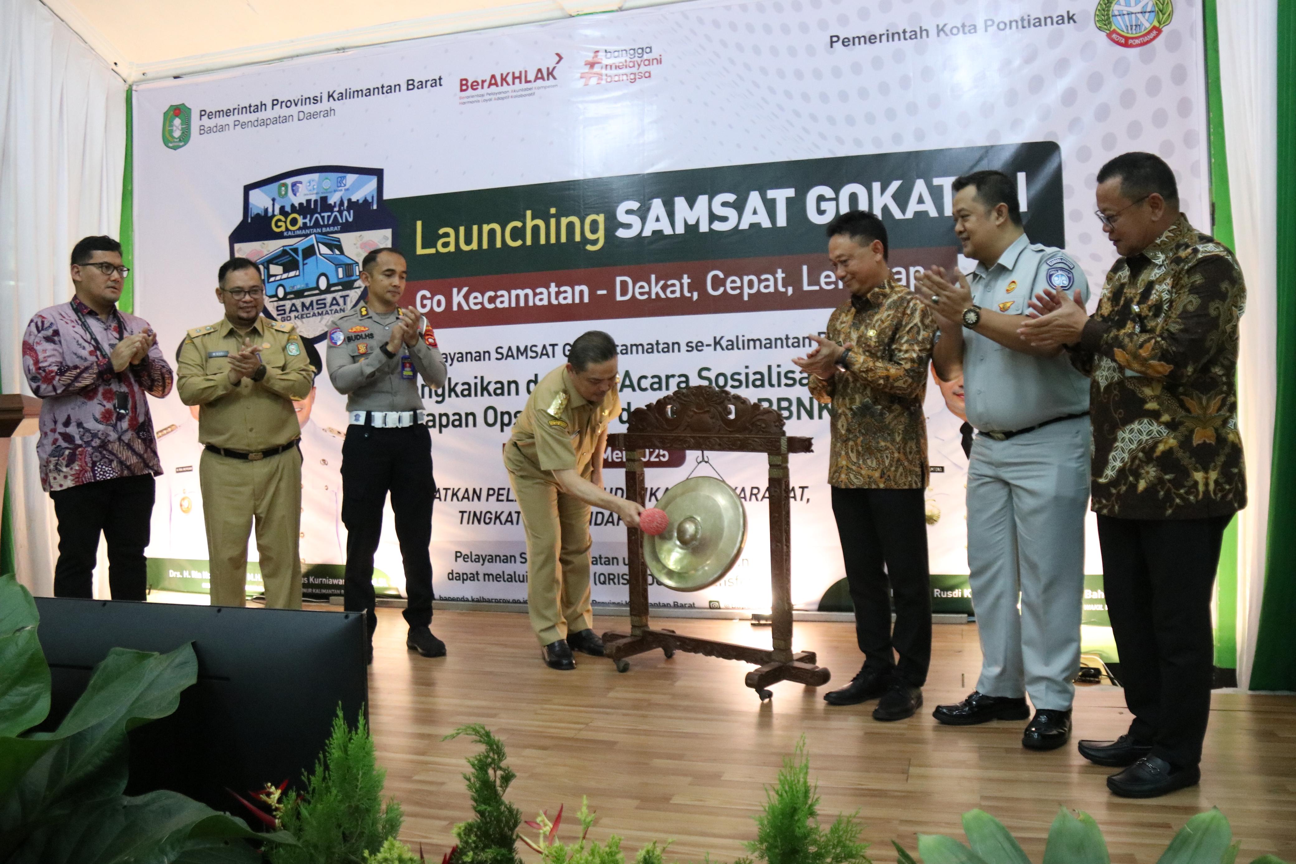 LAUNCHING: Gubernur Kalbar Ria Norsan memukul gong sebagai tanda resmi peluncuran program Samsat Gokatan (Go Kecamatan) di Aula Kantor Camat Pontianak Barat, Selasa (27/5).