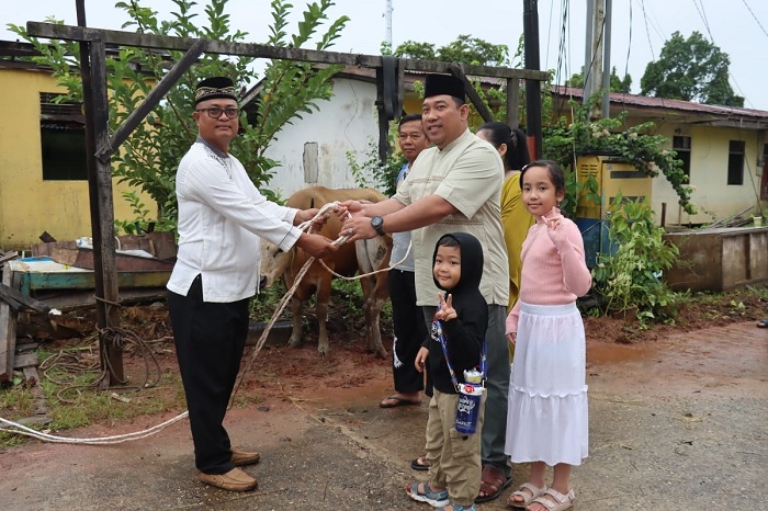 KURBAN: Kapolres Kapuas Hulu bersama keluarga saat menyerahkan hewan kurban kepada panitia.