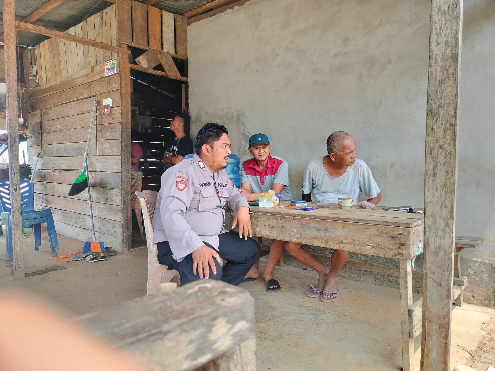 PESAN : Anggota Polsek Sengah Temila saat menyambangi warga di warung kopi, untuk menyampaikan pesan-pesan Kamtibmas.