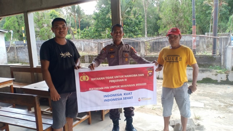 Anggota Polsek Menjalin saat melakukan edukasi bahaya Narkoba dan judi online dengan membentangkan spanduk.