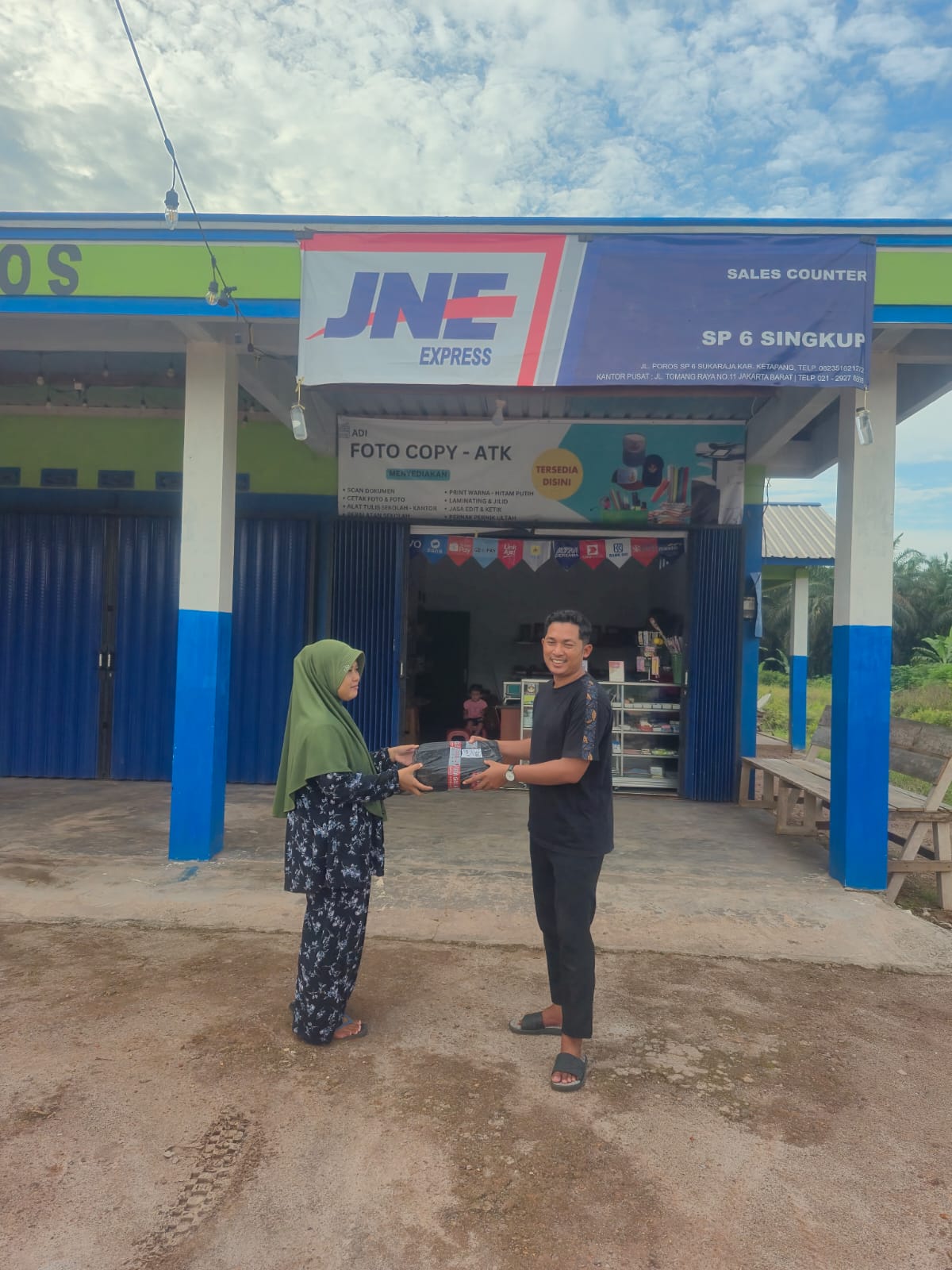Pekerja menerima paket yang diambil di Agen JNE di wilayah perkebunan di Kecamatan Singkup, Kabupaten Ketapang, Kalimantan Barat, 10 Juni 2025. (Mirza Ahmad Muin)