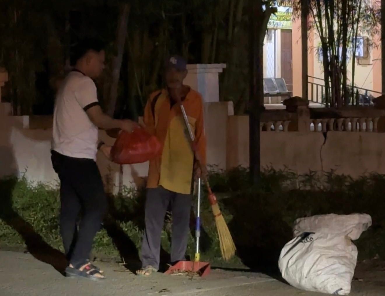 BAGIKAN SEMBAKO: Ketua AJK, Theo Bernadhi, menyerahkan paket sembako kepada salah satu penyapu jalan saat aksi berbagi di pagi hari, Minggu (29/6).