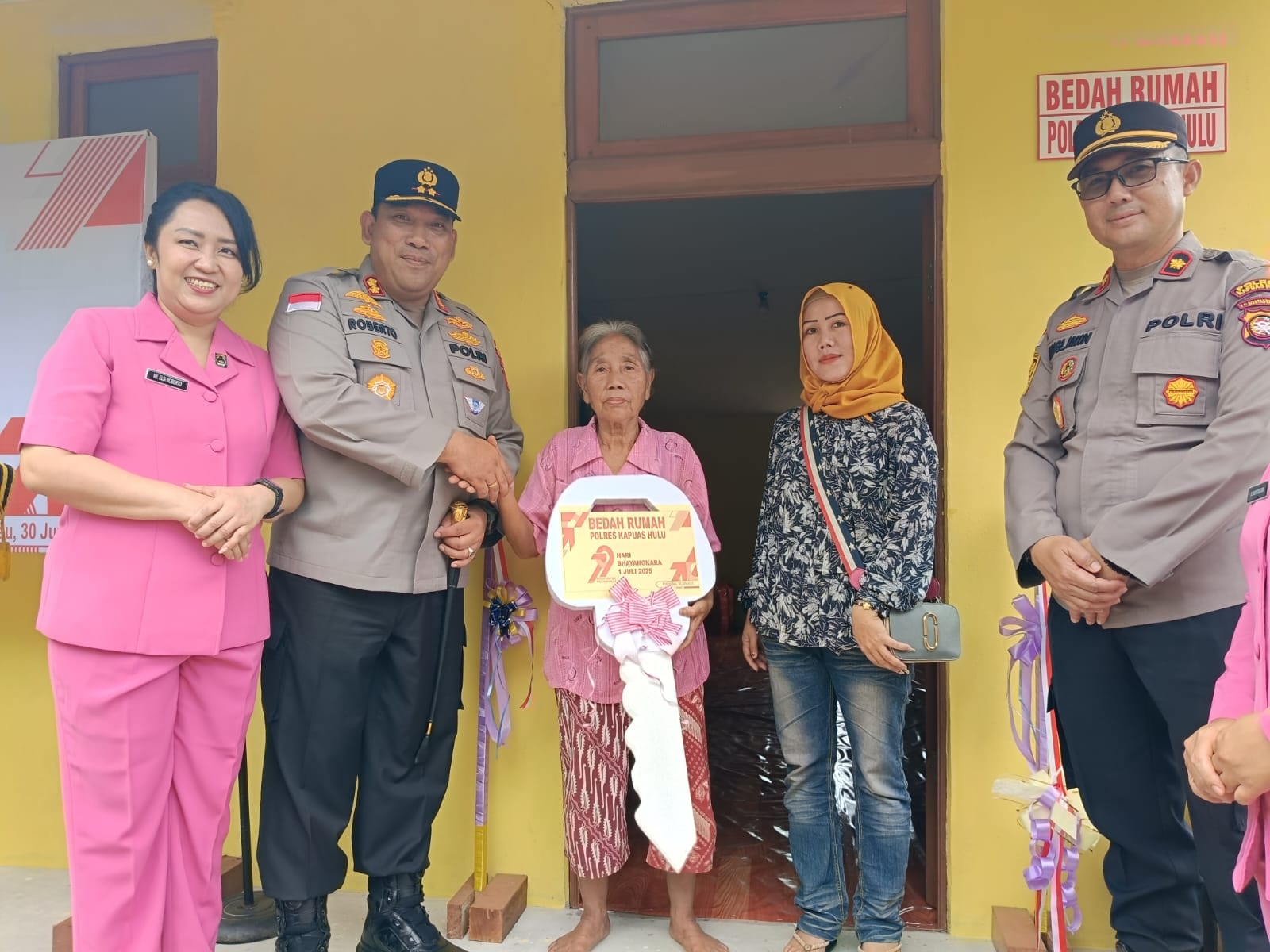 RUMAH : Penyerahan kunci rumah secara simbolis dari Kapolres Kapuas Hulu kepada penerima bantuan rehab rumah Yustina Bunga.