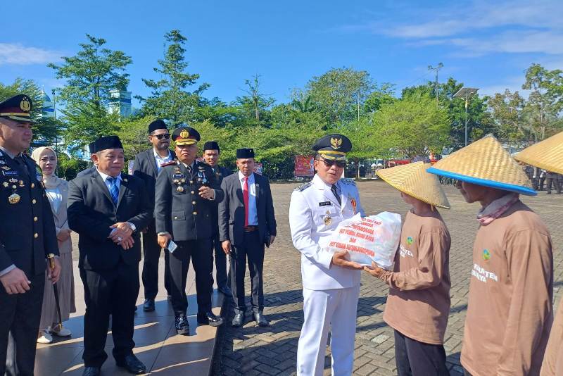 Bupati Kubu Raya, Sujiwo, bersama Kapolres Kubu Raya, AKBP Kadek Ary Mahardika, menyerahkan sembako secara simbolis kepada perwakilan petani usai upacara Hari Bhayangkara di Kantor Bupati Kubu Raya.