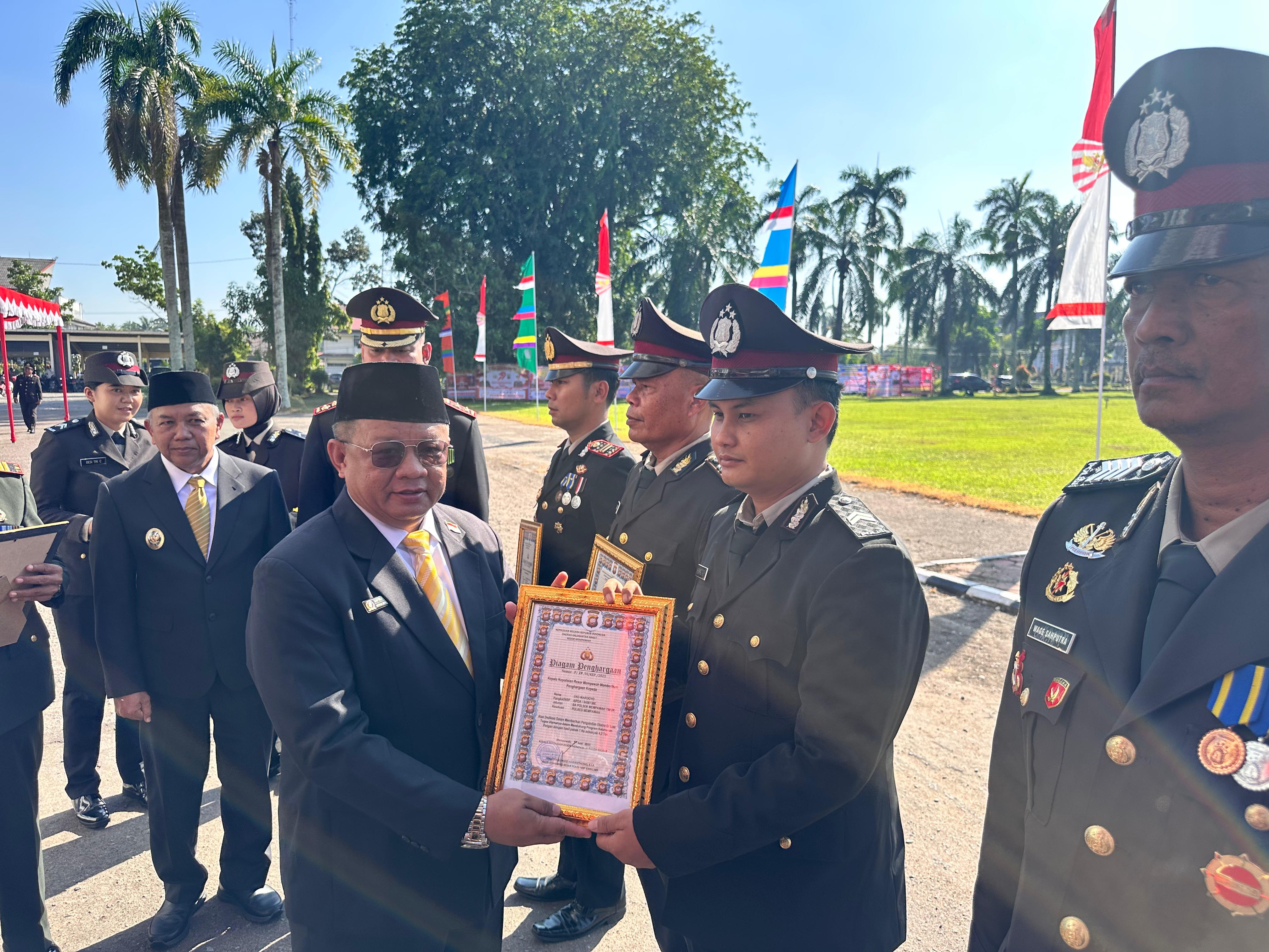 PIAGAM: Ketua DPRD Kabupaten Mempawah memberikan piagam penghargaan kepada anggota Polri saat momen HUT Bhayangkara.