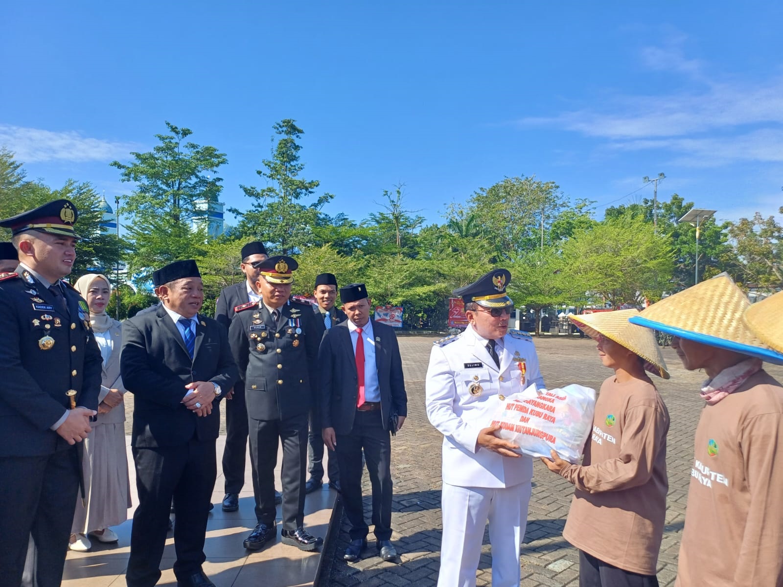 BANTUAN: Bupati Kubu Raya, Sujiwo, bersama Kapolres Kubu Raya, AKBP Kadek Ary Mahardika, menyerahkan bantuan sembako secara simbolis kepada perwakilan petani usai upacara HUT Bhayangkara ke-79. (1/7)