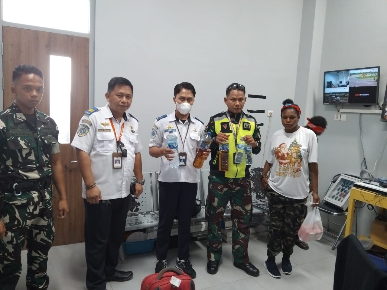 Satgas Kopasgat dan petugas Bandara Nabire menunjukkan barang bukti minuman beralkohol yang disamarkan dalam botol air mineral, usai gagalkan penyelundupan oleh penumpang tujuan Sugapa, Selasa (1/7).