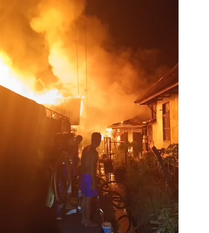 Warga berupaya memadamkan api yang membakar permukiman padat di Gang Baru, Pontianak, Sabtu malam (5/7/2025). Dua rumah ludes terbakar, dan tiga petugas pemadam mengalami luka dalam insiden tersebut.