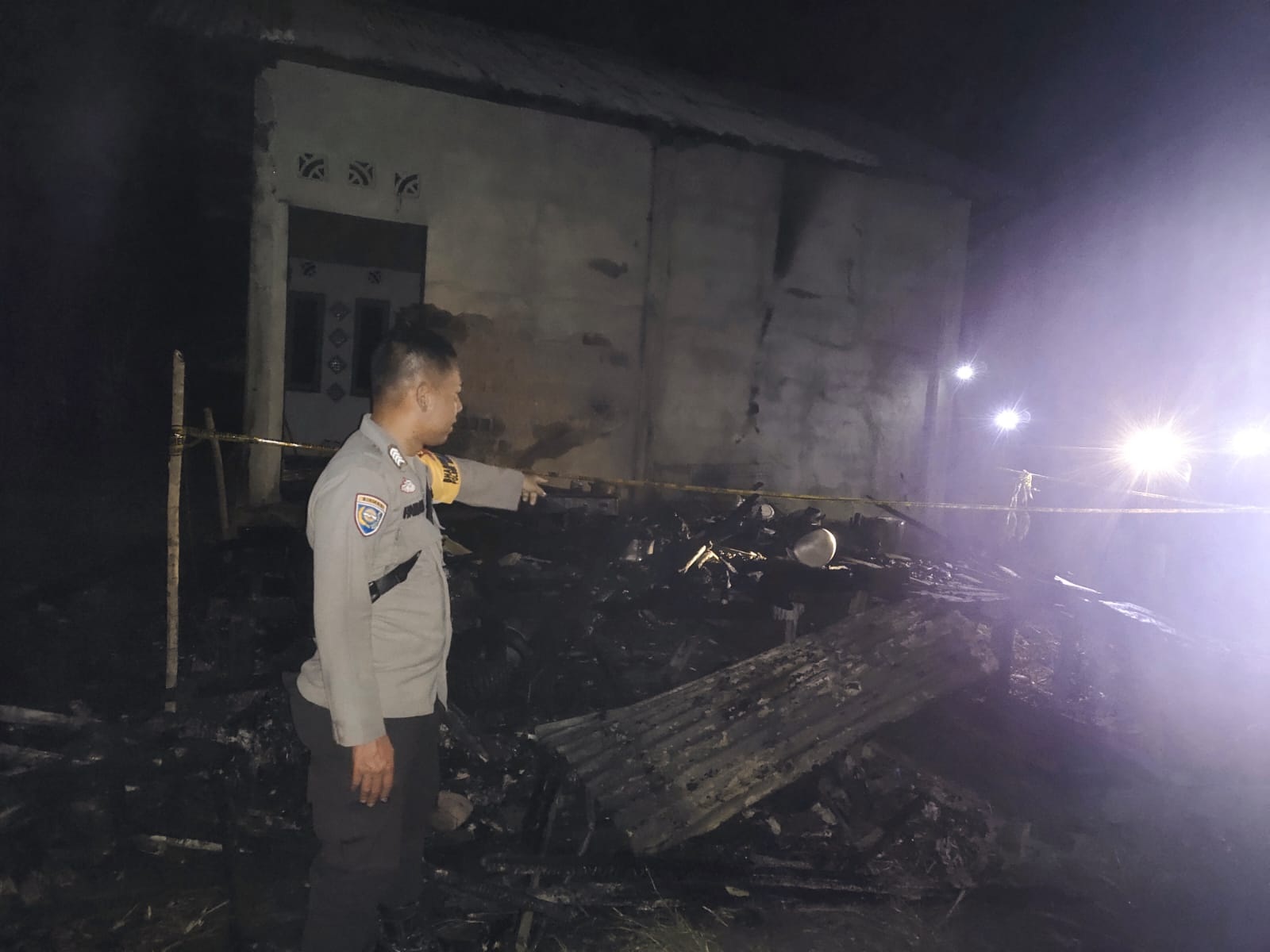 KEBAKARAN: Anggota Polsek Mempawah Hulu saat mendatangi lokasi kebakaran rumah di Dusun Kunyit, Desa Tunang, Kecamatan Mempawah Hulu, Kabupaten Landak, hangus terbakar, Sabtu malam (5/7).