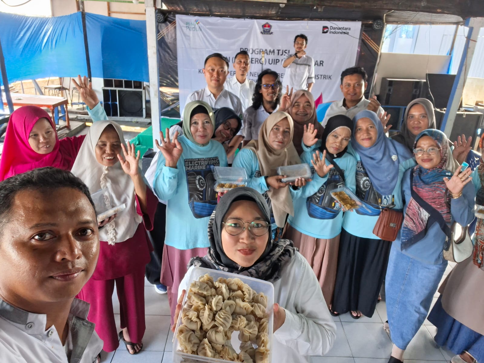Peserta pelatihan penyuluhan pengolahan hasil laut menunjukkan hasil olahan mereka bersama tim PLN UIP Kalbar dalam program TJSL Electrifying Marine di Desa Sungai Kakap, Kubu Raya.