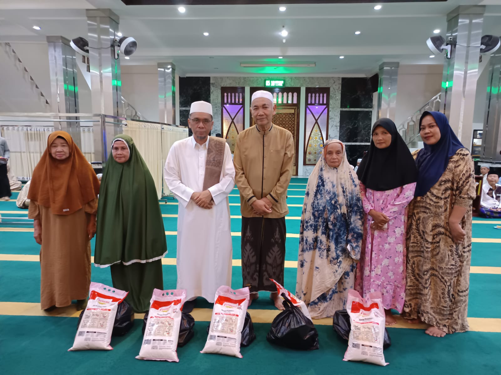 Pengurus Masjid Ikhwanul Mukminin berfoto bersama para penerima santunan usai kegiatan Gerakan Safah Marwah yang digelar Ahad, 13 Juli 2025.