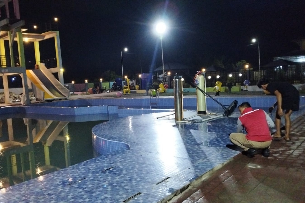 Petugas kepolisian saat olah TKP di kolam renang setelah ada anak meninggal di tempat tersebut.
