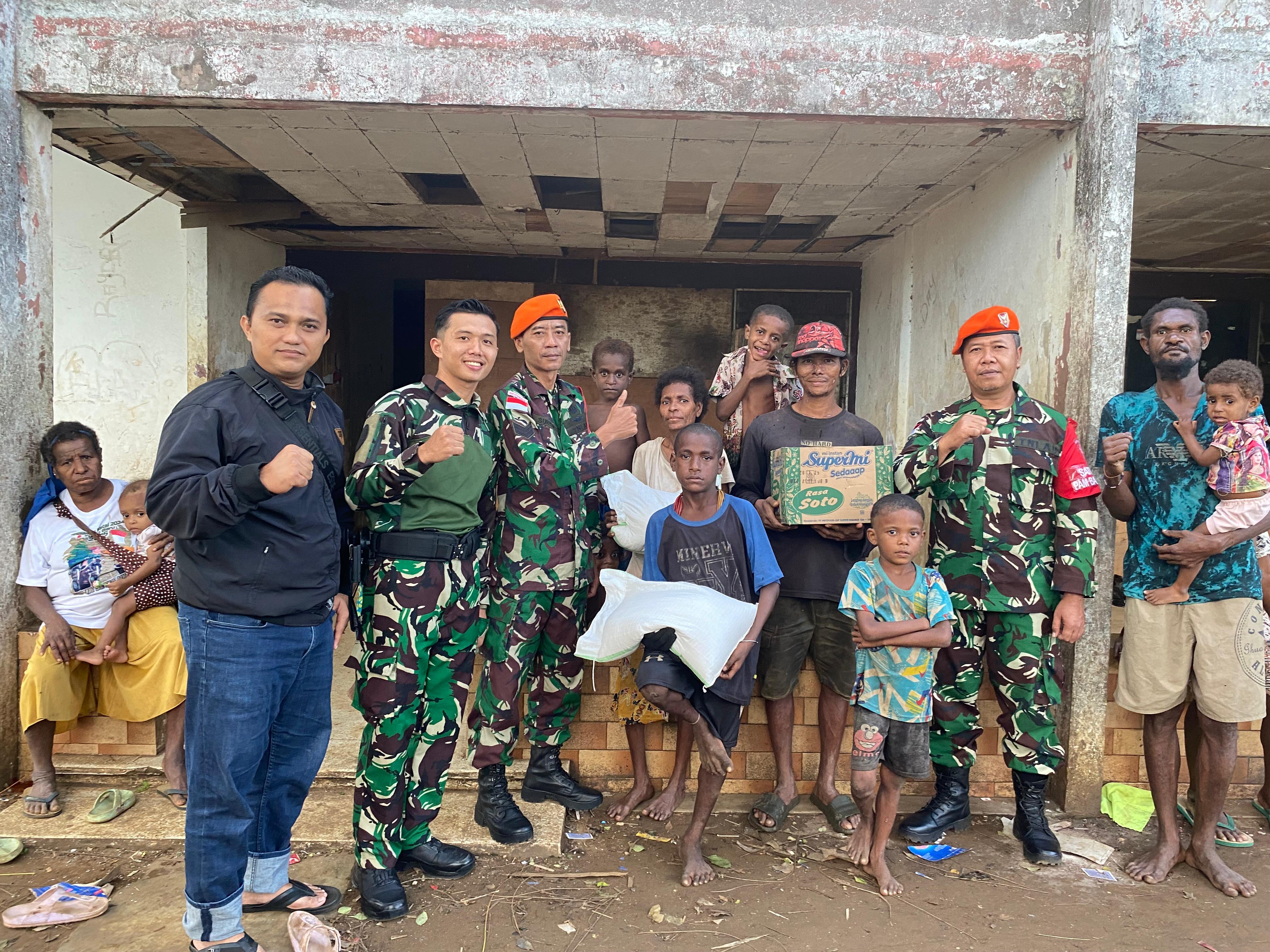 Prajurit Yonko 465 Kopasgat bersama warga Merauke usai menyalurkan bantuan sosial langsung ke rumah-rumah.