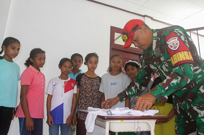 Anggota TNI memberi contoh cara melipat pakaian dengan rapi kepada para siswa di Sekolah Rakyat Menengah Pertama (SRMP) 19 Kupang, Naibonat, Kabupaten Kupang, Nusa Tenggara Timur, Jumat (18/7/2025). Di Sekolah Rakyat tersebut anggota TNI-POLRI membantu me